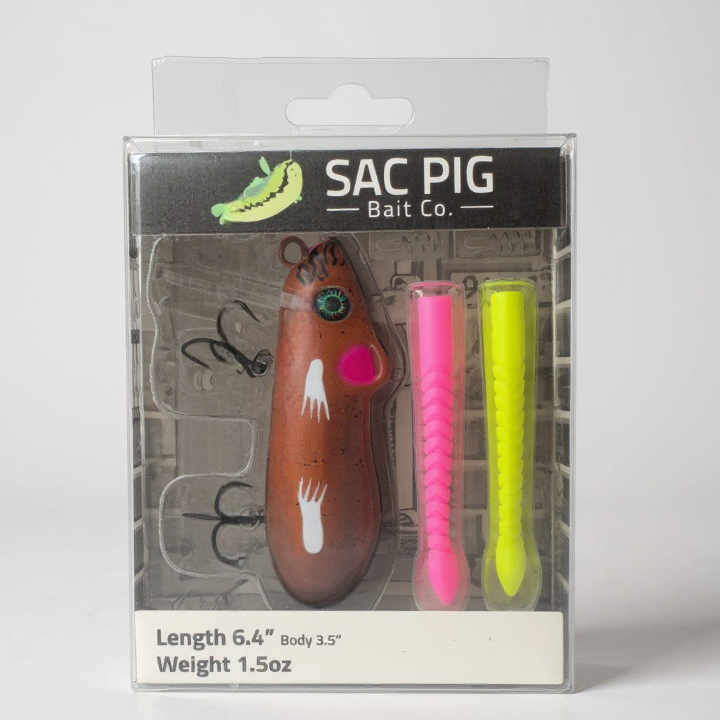 SAC PIG Bait Co. fishing lure packaging with a brown lure, pink and yellow trailers, and brand name on a gray background.